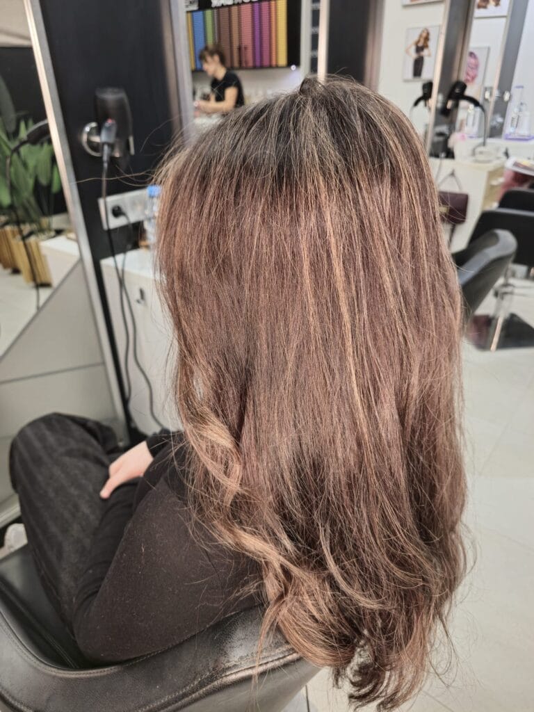 Włosy po koloryzacji w ciepłym świetle – subtelne pasemka i miękki połysk, profesjonalna koloryzacja Agneess Warszawa Ursynów.