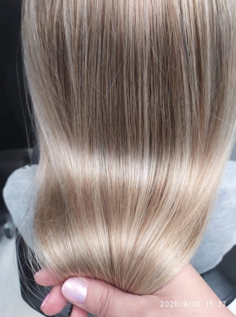 Koloryzacja beżowy blond w chłodnej tonacji na długich, prostych włosach. Blask i zdrowy wygląd. Praca Salonu Agneess.