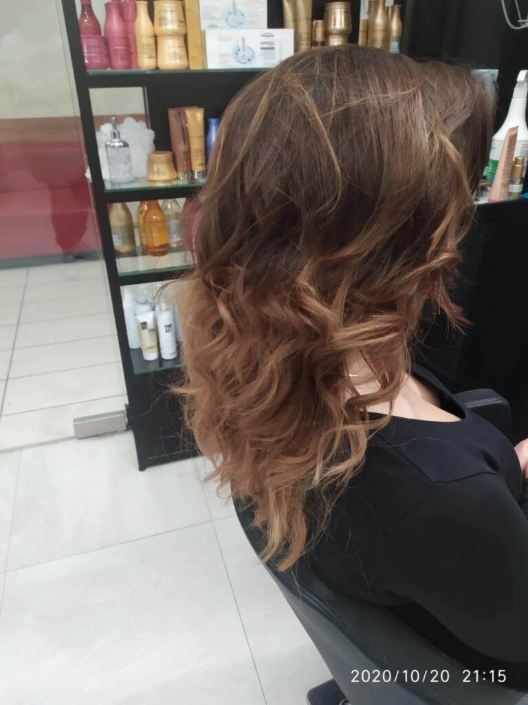 Koloryzacja ombre/sombre na brązowych, falowanych włosach. Ciepłe odcienie miedzi i karmelu na końcach. Praca Salonu Agneess.