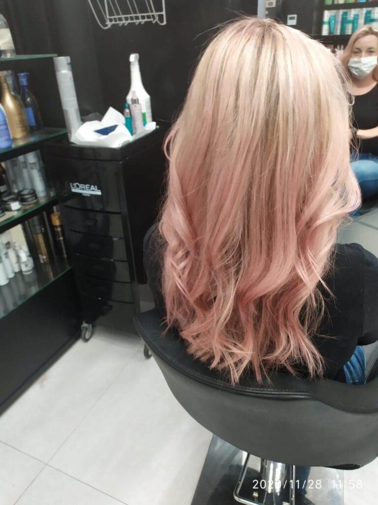 Koloryzacja blond z pastelowym różowym ombre na końcach. Modne pofalowane włosy. Koloryzacja kreatywna w Agneess.