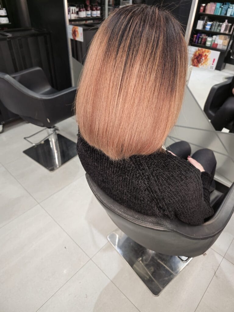 Efekt końcowy koloryzacji – ciepły balejaż na włosach średniej długości, wykonany w salonie fryzjerskim Agneess na Ursynowie w Warszawie.