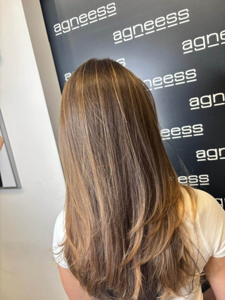 Refleksy muśnięte słońcem na długich włosach – subtelne rozświetlenie wykonane w salonie Agneess na Ursynowie