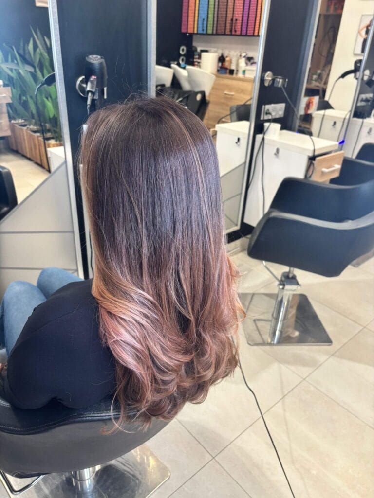 Efekt koloryzacji Sombre – lśniące włosy w odcieniu karmelowym i głęboki brąz. Fryzjer Warszawa Ursynów.